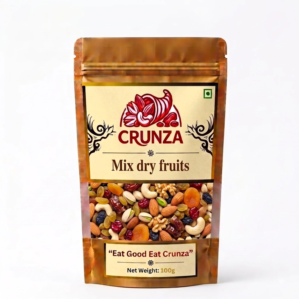 A 100g stand-up pouch of CRUNZA Mix Dry Fruits on a clean white background. The packaging is metallic gold with a beige label featuring the red CRUNZA logo and a clear window showing the mixed fruits inside.